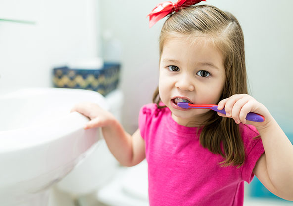 little girl brushing her teeth