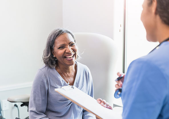 A 50-year-old woman at an urgent care talking with a nurse