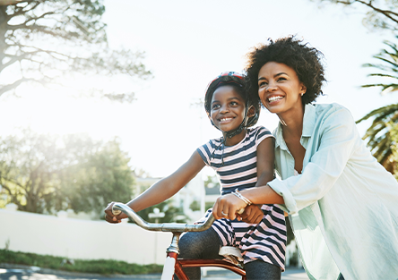 A mother teaching her daughter how to ride a bike