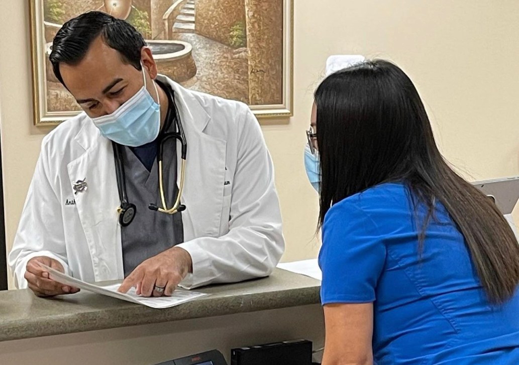 A doctor going over paperwork with the front desk