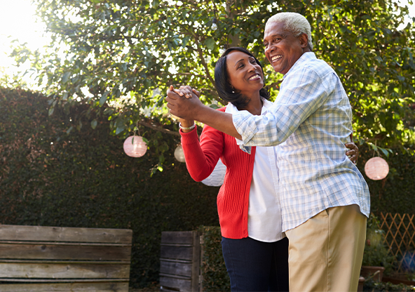 A senior black couple dancing outside