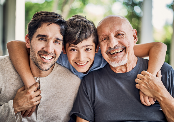 Three generations of men smiling and hugging 