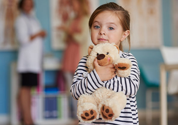 A little girl holding her teddy bear