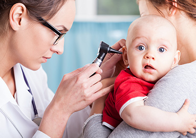 Doctor checking a baby's ear with an otoscope