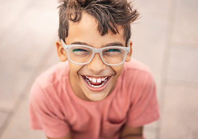 Boy in glasses smiling outside