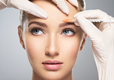 Young woman receiving botox in her face.