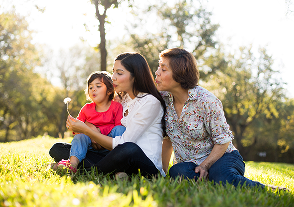 A happy Hispanic family outdoors and the grandma is recovering from a heart procedure