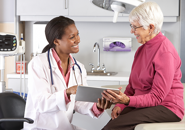 A young black physician with a woman patient