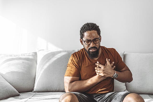 African American man holding his chest in pain