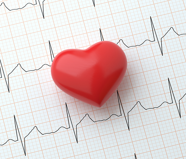 A heart cut out laying on top of a EKG report