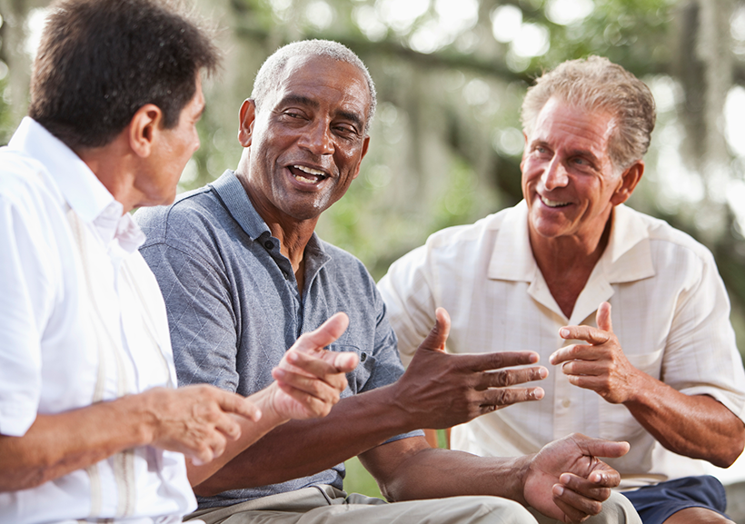 Three older men talking to each other