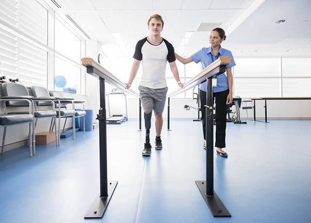 Male leg amputee walking in therapy