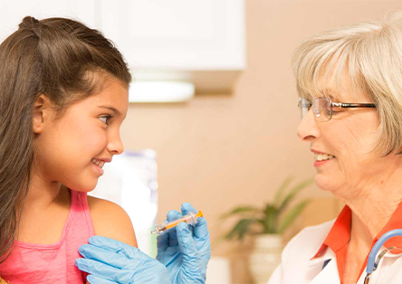 A female doctor giving a little girl a flu shot