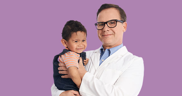 Dr. Bautista holding a child with a pediatric heart condition