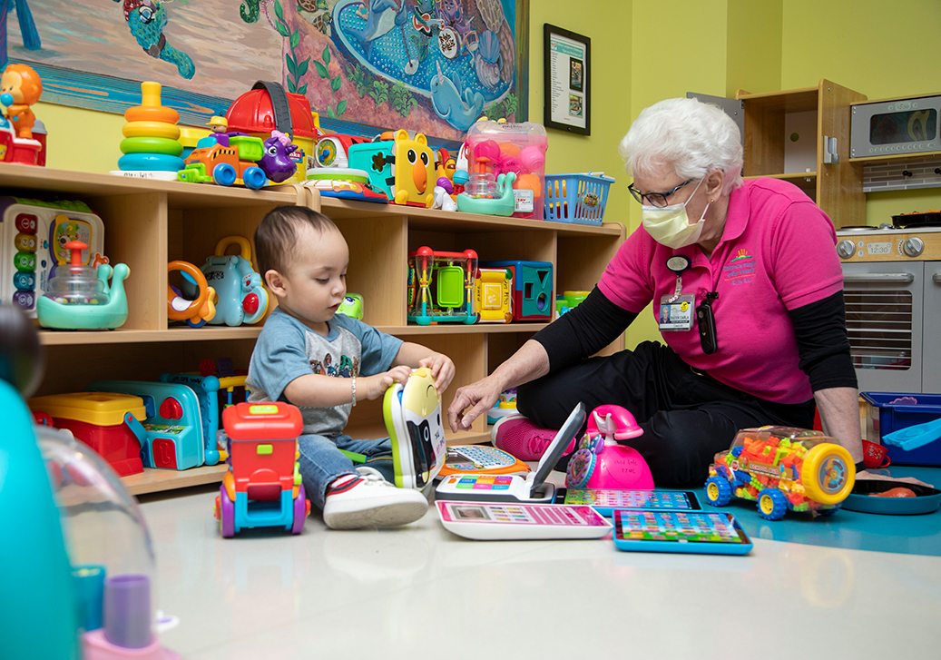 The Children's Hospital of San Antonio's child life specialist playing with a child to take their mind off of an inpatient stay.