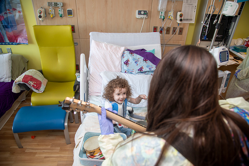 Child Life Therapist at The Children's Hospital of San Antonio music therapy with happy patient
