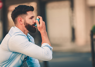 man using his inhaler