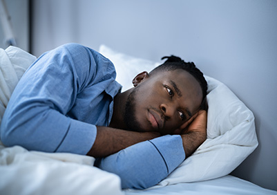 Black man struggling to fall asleep