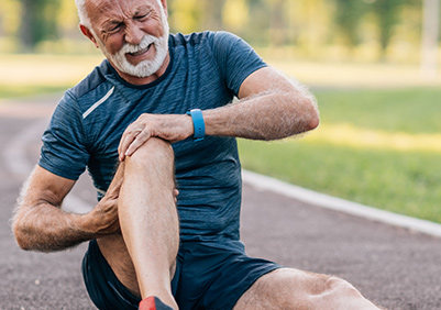 Older man sitting on the track with a hurt knee