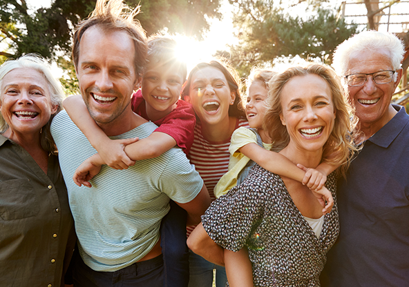 A Caucasian multi-generational family smiling outside  