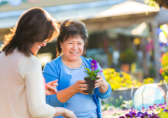 A Latin mother and daughter shopping for flowers at a gardening store